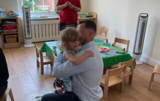 father hugging daughter at nursery