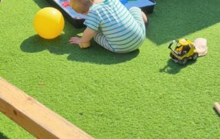 father playing in nursery garden with baby