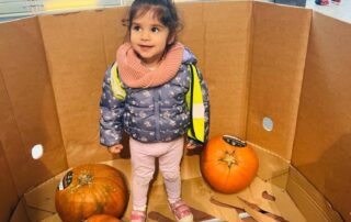 nursery child choosing pumpkins