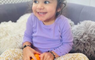 nursery child holding pumpkins