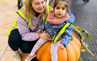 nursery child sat on a giant pumpkin