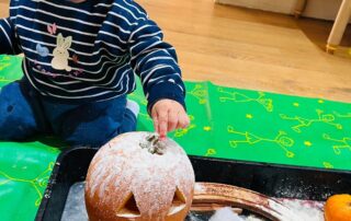 nursery child with carved pumpkin