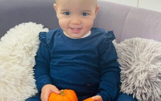 nursery child with small pumpkins