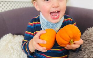 nursery child with two pumpkins