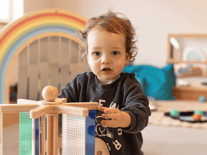 child playing with wooden toy